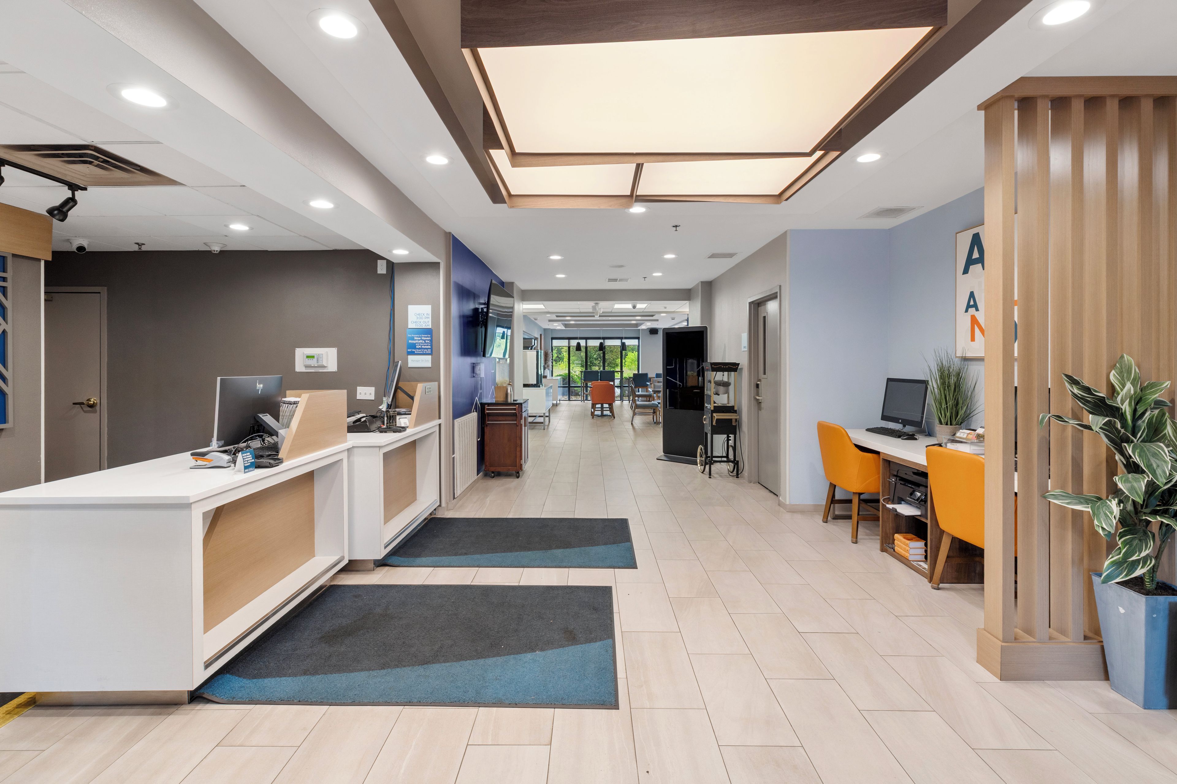 A reception area with a desk, computer, and seating area with chairs.