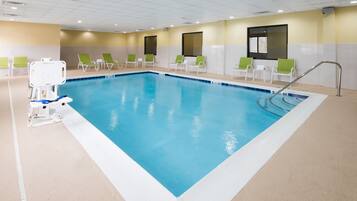 Een binnenzwembad, ligstoelen bij het zwembad