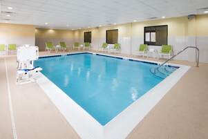 Una piscina techada, sillones reclinables de piscina