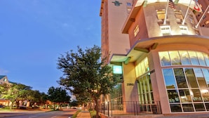 A hotel with a curved facade, large windows, and a visible address number.