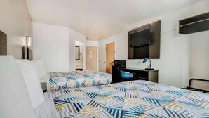Ein Hotelzimmer mit einem großen Bett, einem Schreibtisch, einem Stuhl und einem Spiegel.