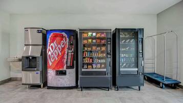 Zona de máquinas expendedoras con dispensador de Dr. Pepper, máquina expendedora de bocadillos y dispensador de bebidas.