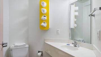 Een badkamer met toilet, wastafel en spiegel.