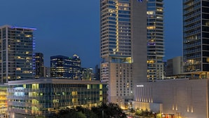 Um hotel moderno com muitos andares, fachada de vidro e o logo 'W' bem visível.
