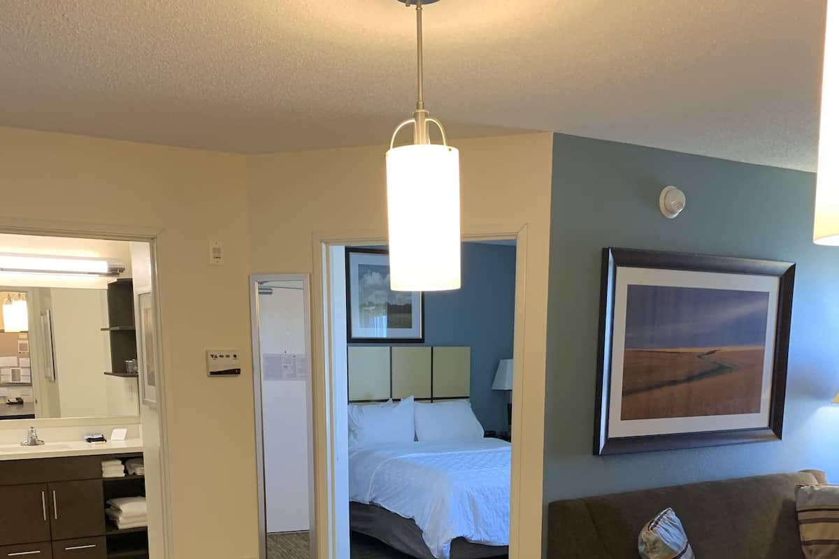 Een hotelkamer met een eethoek, een bed, een badkamer en een zithoek.
