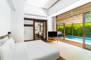 Una habitación de hotel moderna con una cama grande, televisión y vistas a una piscina.