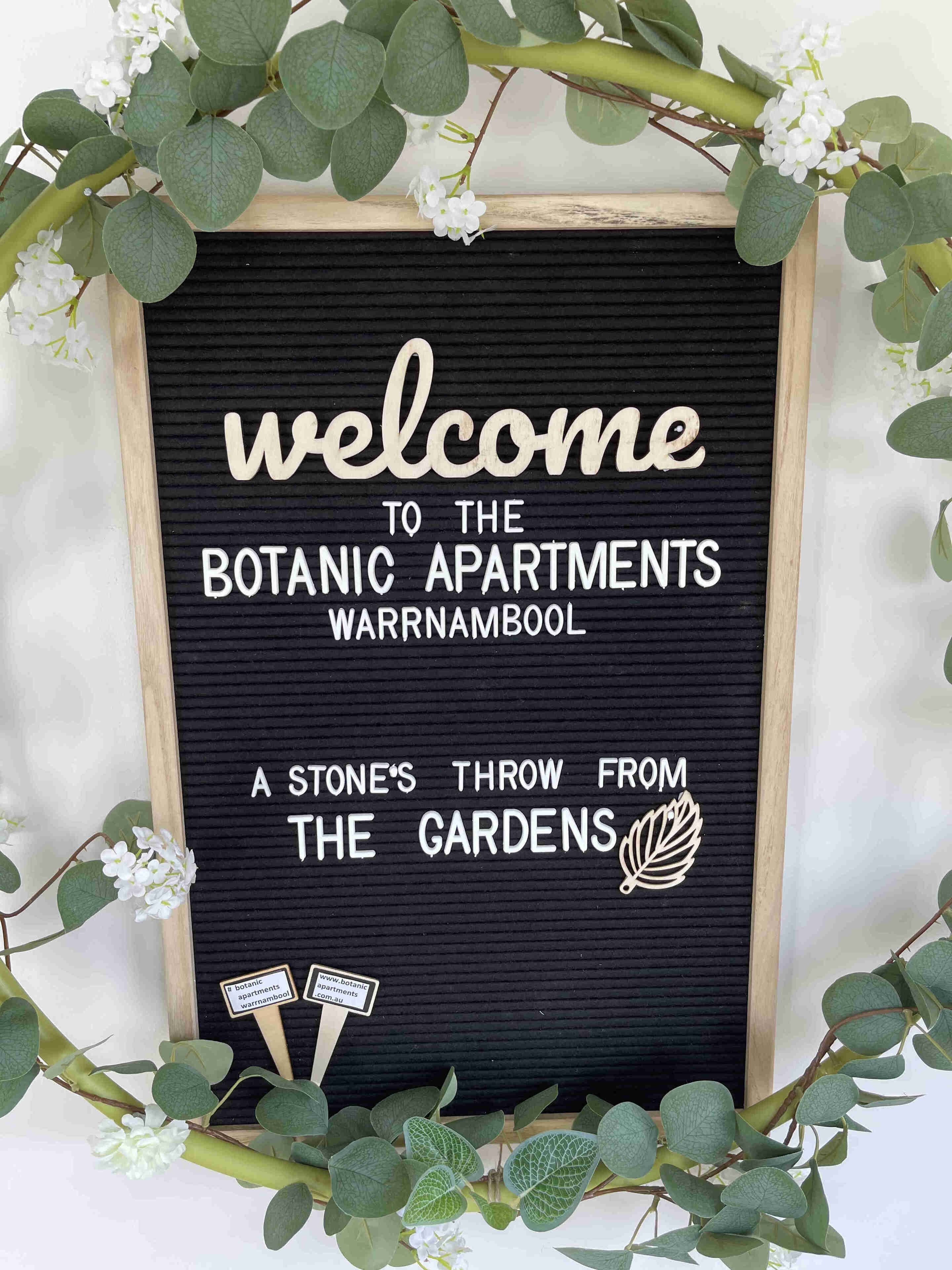 A welcome sign for the Botanical Apartments in Warrnambool, featuring a stone's throw from the gardens.