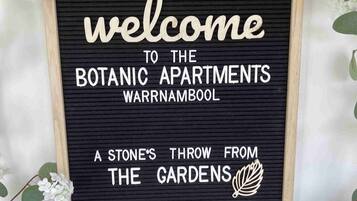 A welcome sign for the Botanical Apartments in Warrnambool, featuring a stone's throw from the gardens.