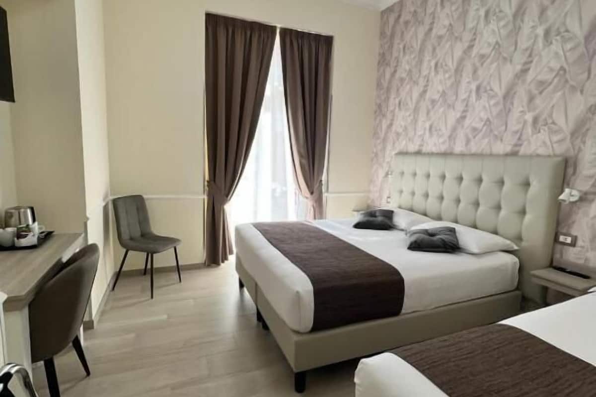 Una habitación de hotel con una cama grande, un escritorio y una silla.