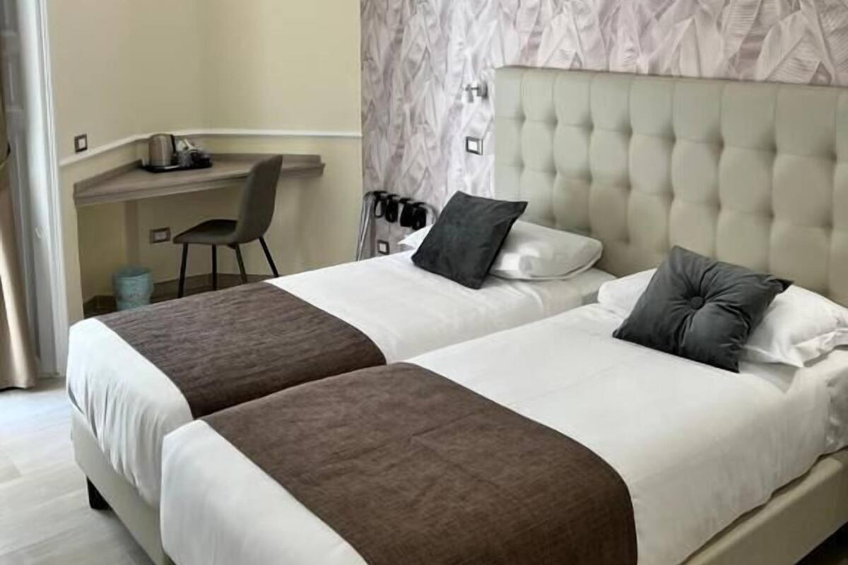 Una habitación de hotel con dos camas, un escritorio y una silla.