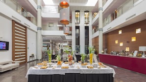 Un amplio espacio interior con una mesa de buffet, asientos y una barra.