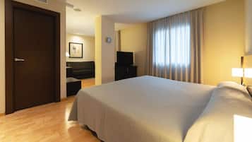 Una habitación de hotel con una cama grande, televisión, sofá y escritorio.