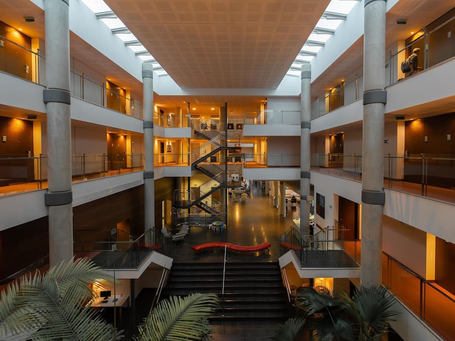 A multi-level atrium with a central staircase, glass railings, and a modern design.