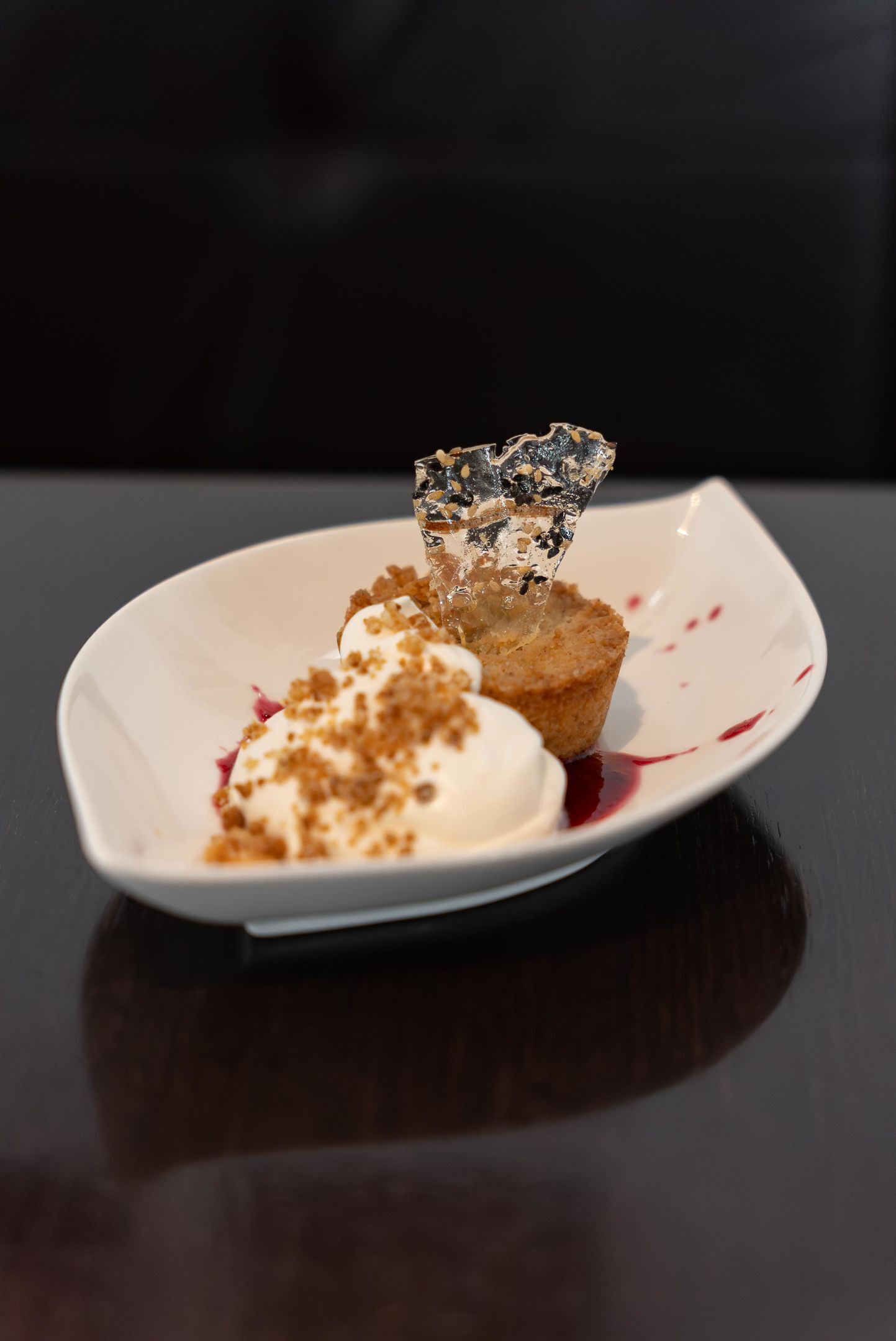 A dessert on a white plate with a dark background.