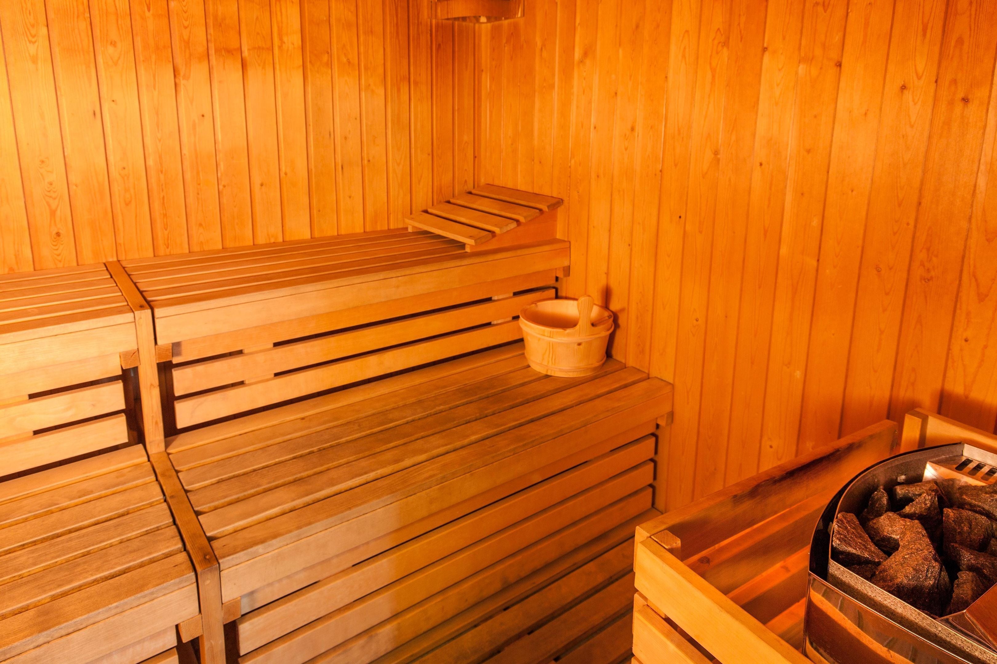 A sauna with wooden benches and a stone basin.