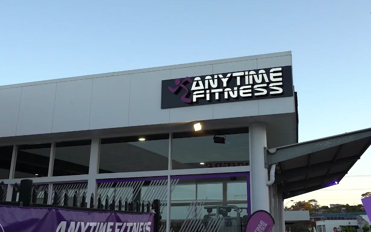 A building with a sign that reads 'ANYTIME FITNESS'.