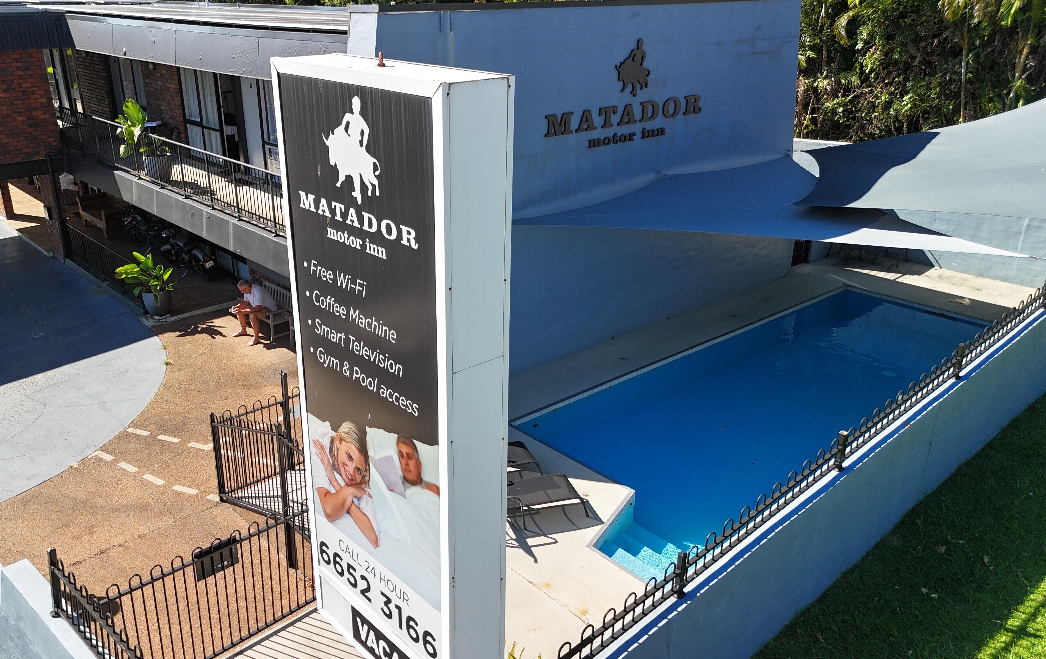 A sign for Matador Motor Inn advertising amenities like free Wi-Fi, coffee machine, smart TV, gym, and pool access.
