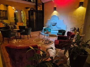 A lounge area with sofas, chairs, and a fountain.
