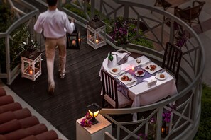 A dining area with a table set for two, surrounded by chairs, and a person walking away. - Marti La Perla Hotel - All Inclusive - Adult Only (Marmaris)