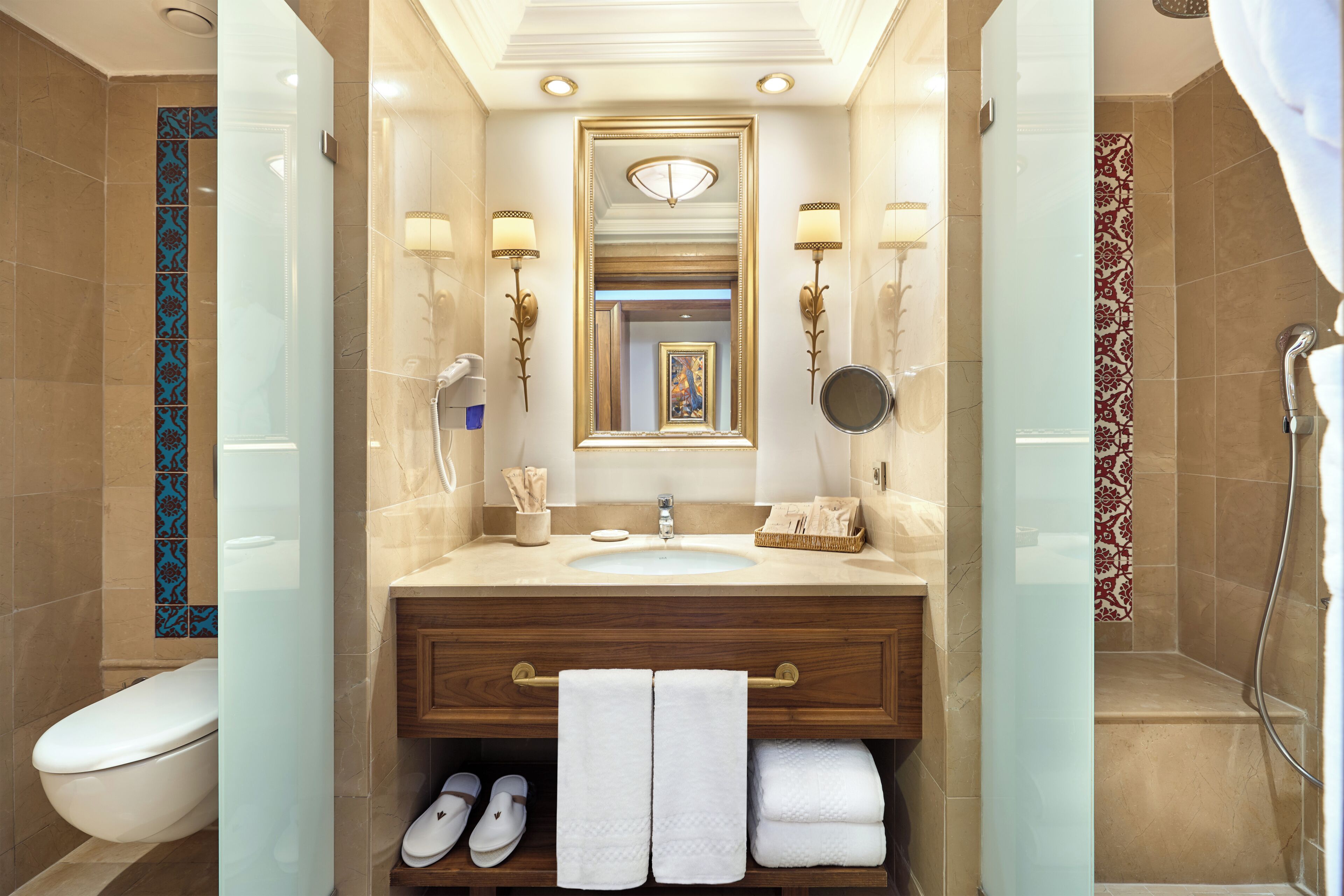 A bathroom with a sink, mirror, towel rack, and shower.