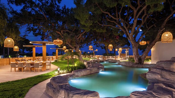 An outdoor dining area with tables and chairs, a small water feature, and hanging lanterns. - Rixos Premium Tekirova - The Land of Legends (Kemer)