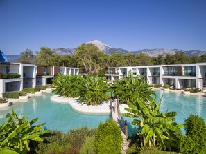 A resort with a pool surrounded by lush greenery and modern buildings.