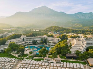A resort with multiple buildings, a central pool area, and surrounding greenery. - Rixos Premium Tekirova - The Land of Legends (Kemer)