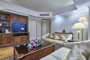A living room with a television, sofa, coffee table, and decorative lamps.