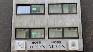 Un bâtiment sur lequel on peut lire deux enseignes indiquant « HÔTEL ACON ACON » et qui arbore le logo de « Frankfurter Altm ».