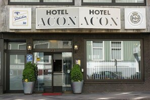 A hotel named "HOTEL ACON ACON" with a number 23 sign above the entrance. There are two potted plants in front of the entrance. - Hotel Acon (Düsseldorf)