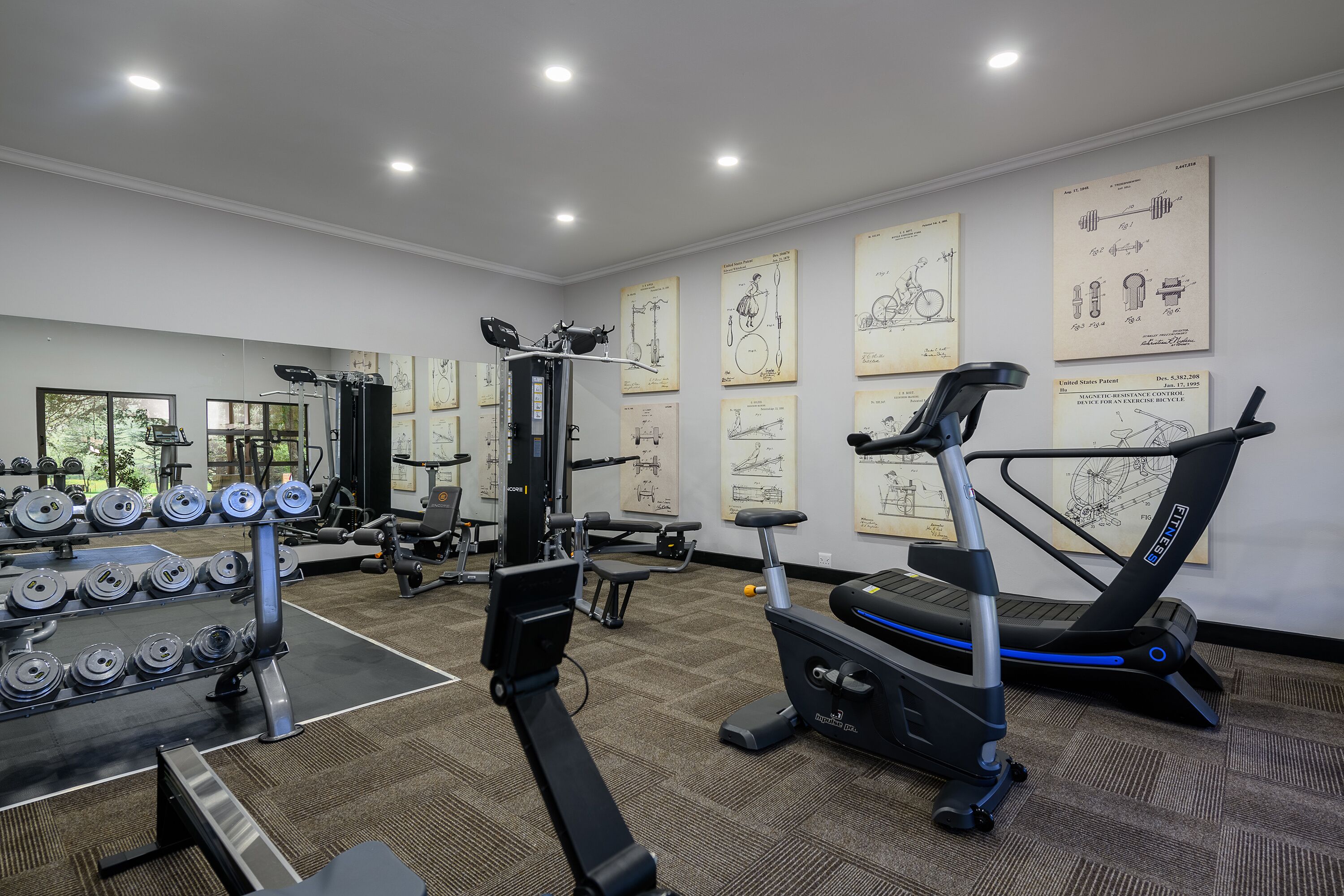 Uma academia com diversos equipamentos de exercícios, incluindo halteres, esteira e aparelhos de musculação.