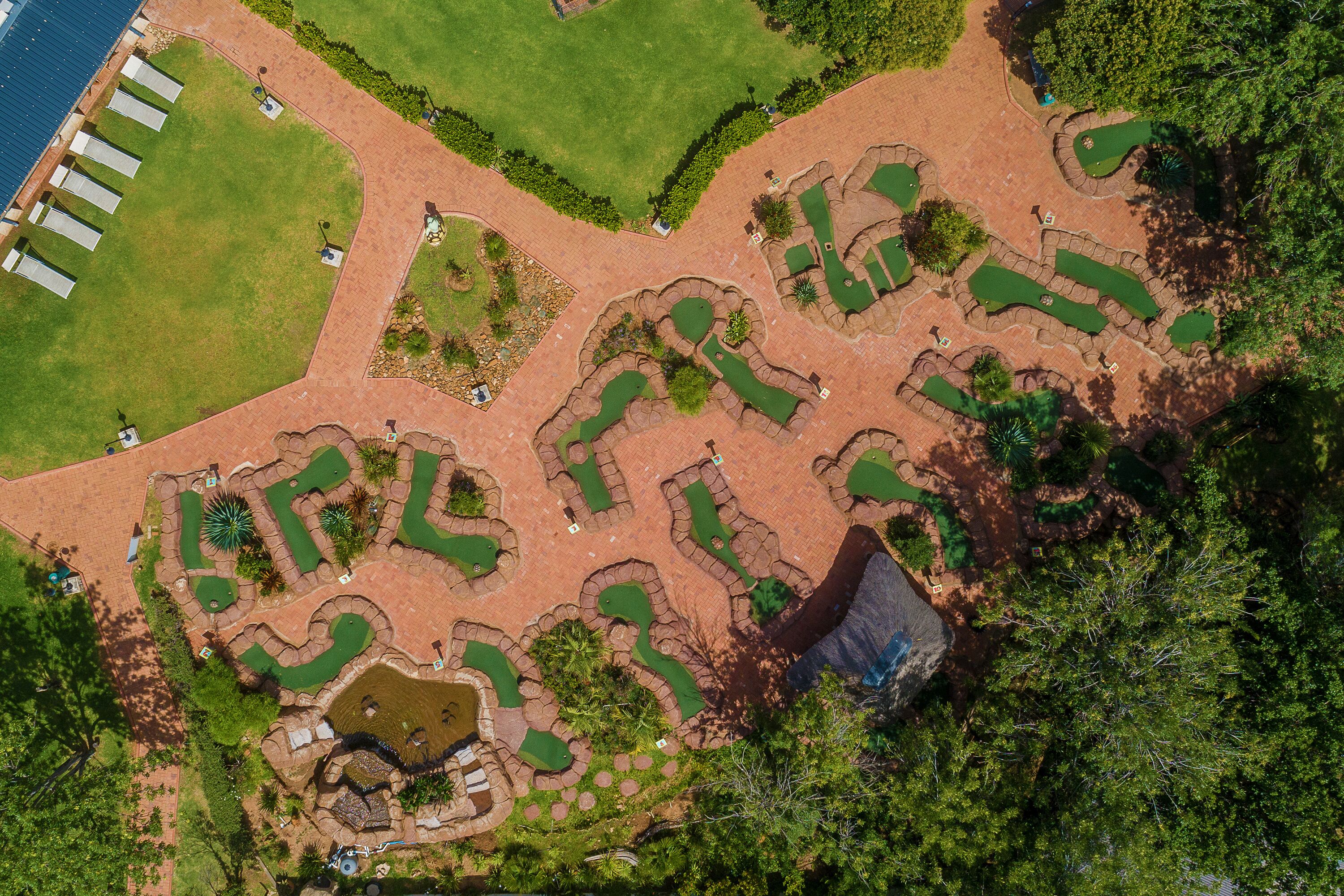 Vista aérea de un campo de golf con múltiples greens, búnkeres y una zona de agua.