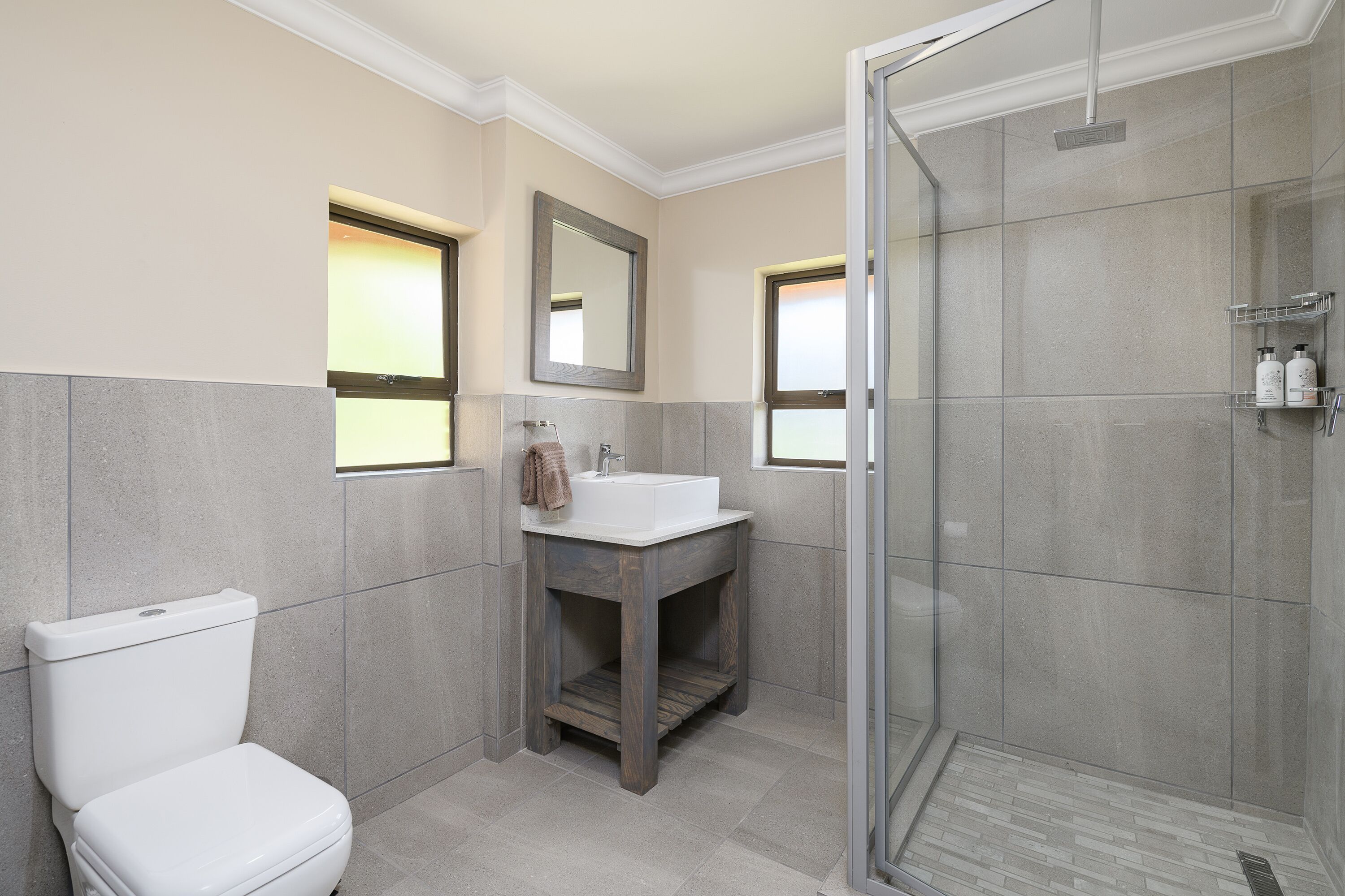 Un baño moderno con inodoro, lavabo y ducha.