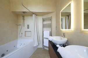 Un baño moderno con bañera, lavamanos y ducha.