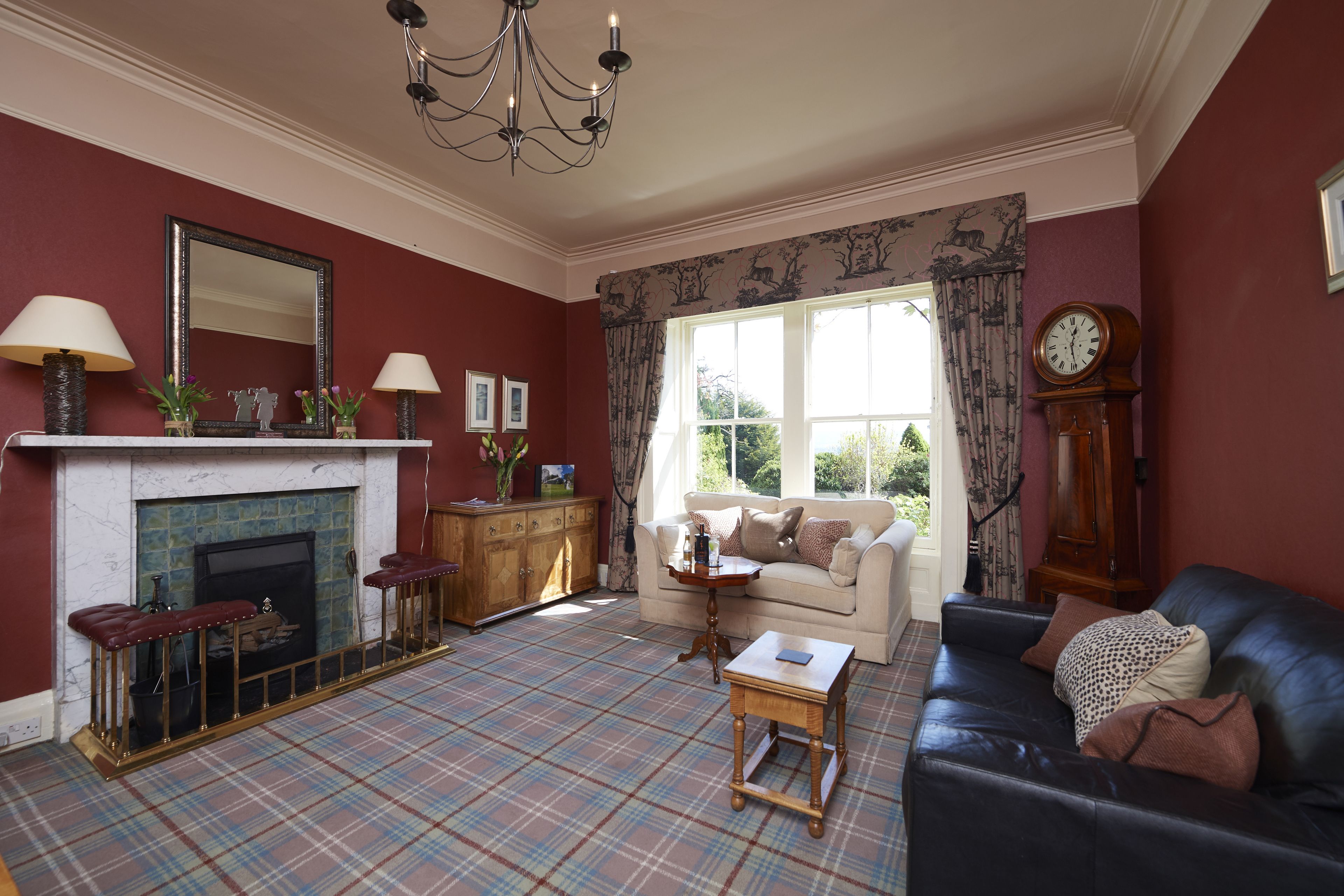 A living room with a fireplace, a sofa, a coffee table, and a clock on the wall.
