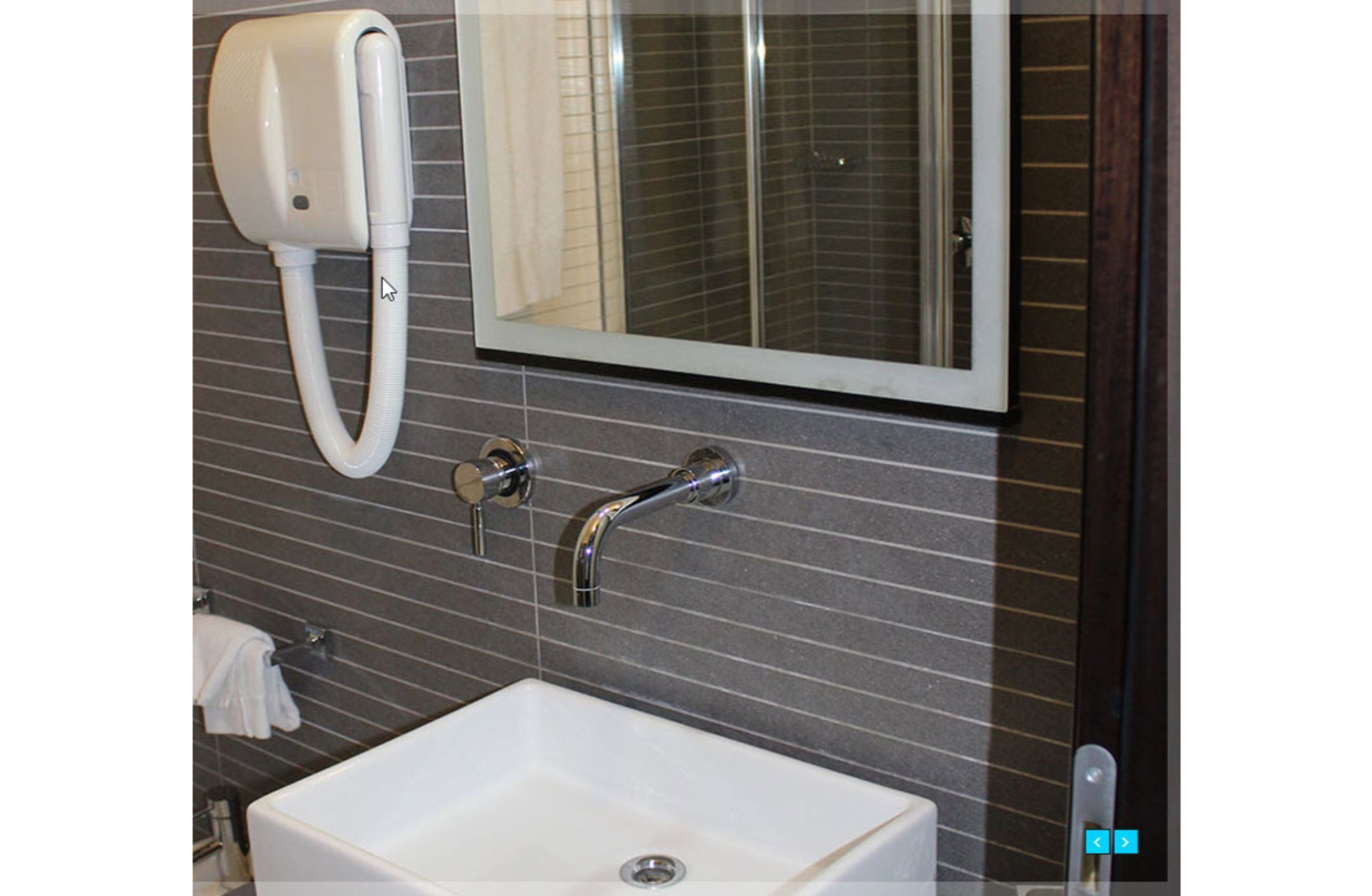 A bathroom with a white sink, a mirror, and a towel rack.
