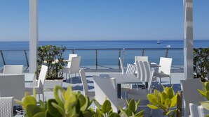 A terrace with white wicker furniture and a view of the sea. - Hotel Admeto (Castelvetrano)