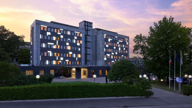 A modern hotel with a symmetrical facade, multiple windows, and a well-maintained garden area. - Best Western Park Hotel Continental (San Dona di Piave)