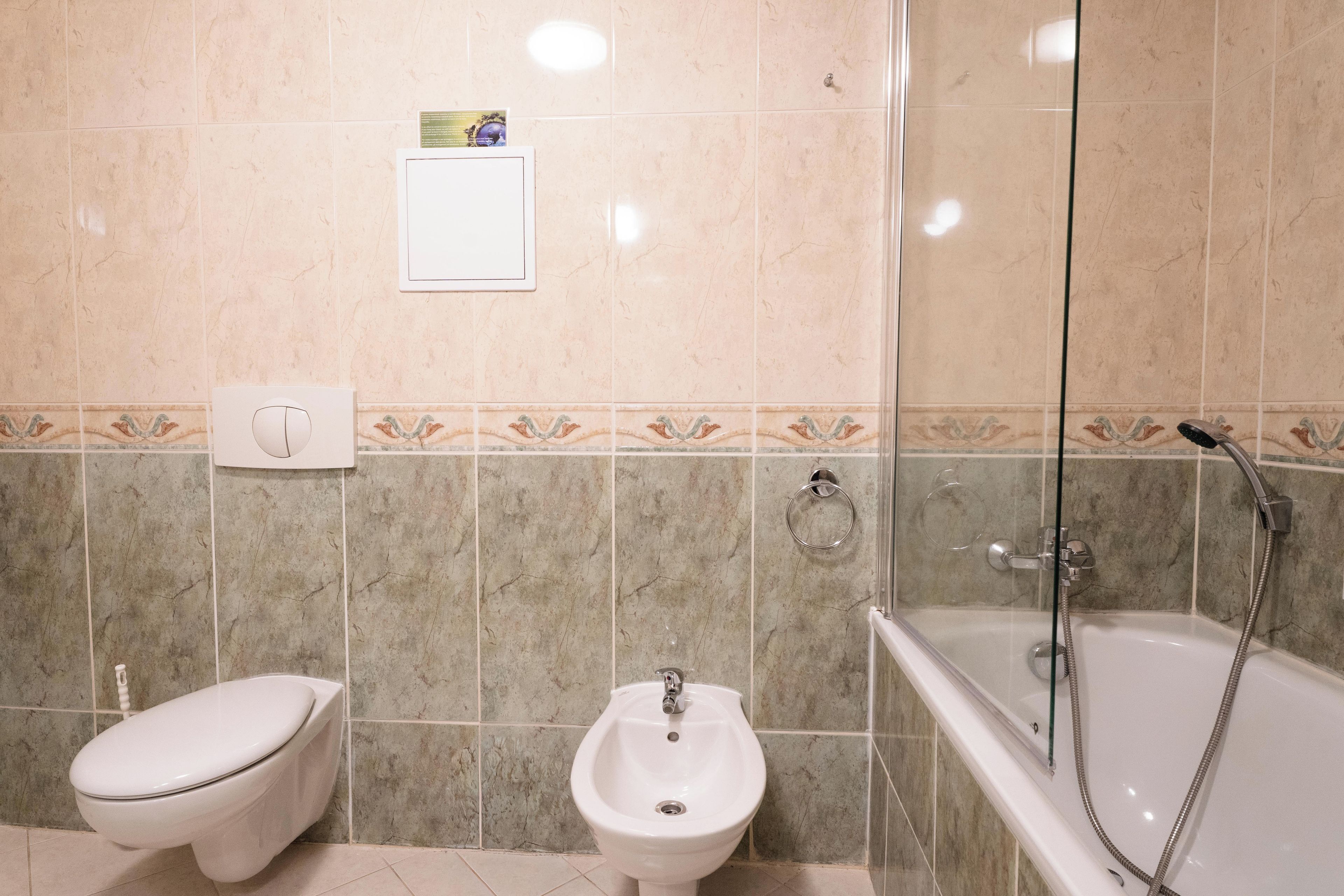 A bathroom with a toilet, bidet, and bathtub.