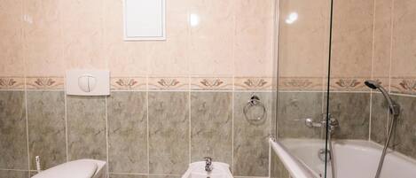 A bathroom with a toilet, bidet, and bathtub.