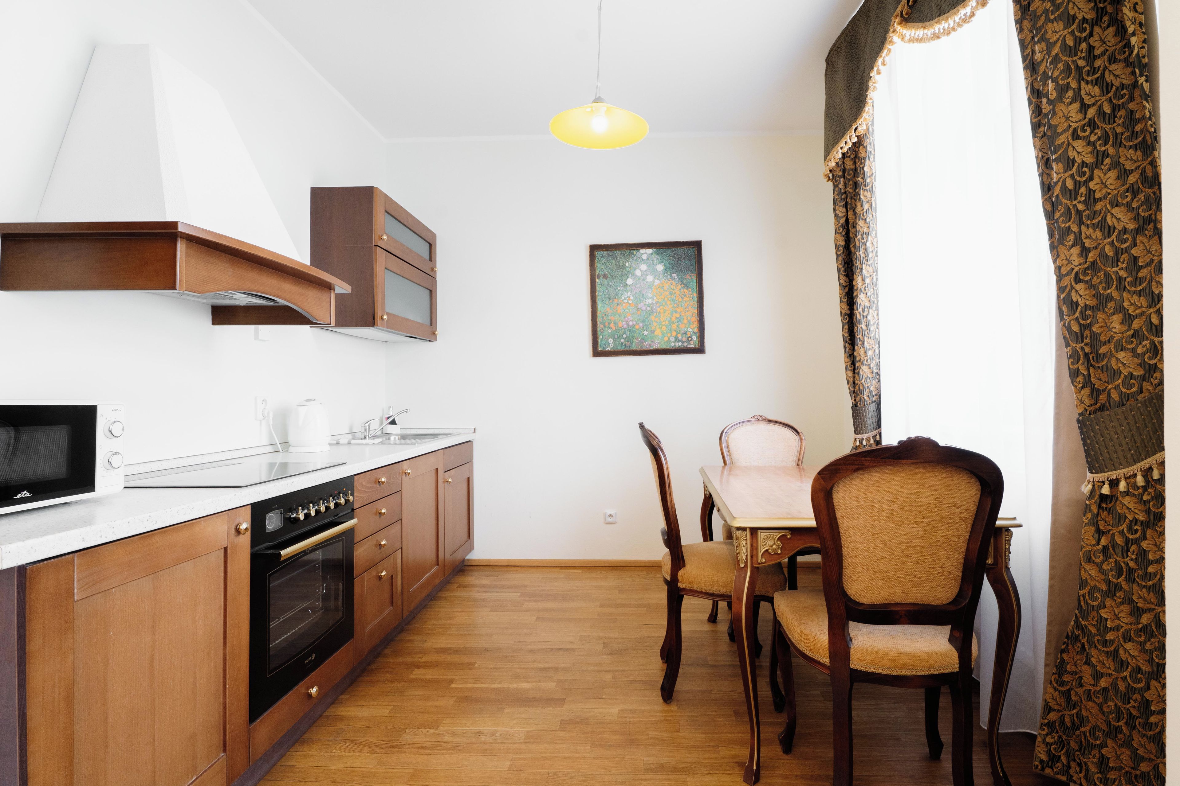 A compact kitchen with a microwave, oven, and wooden cabinets.