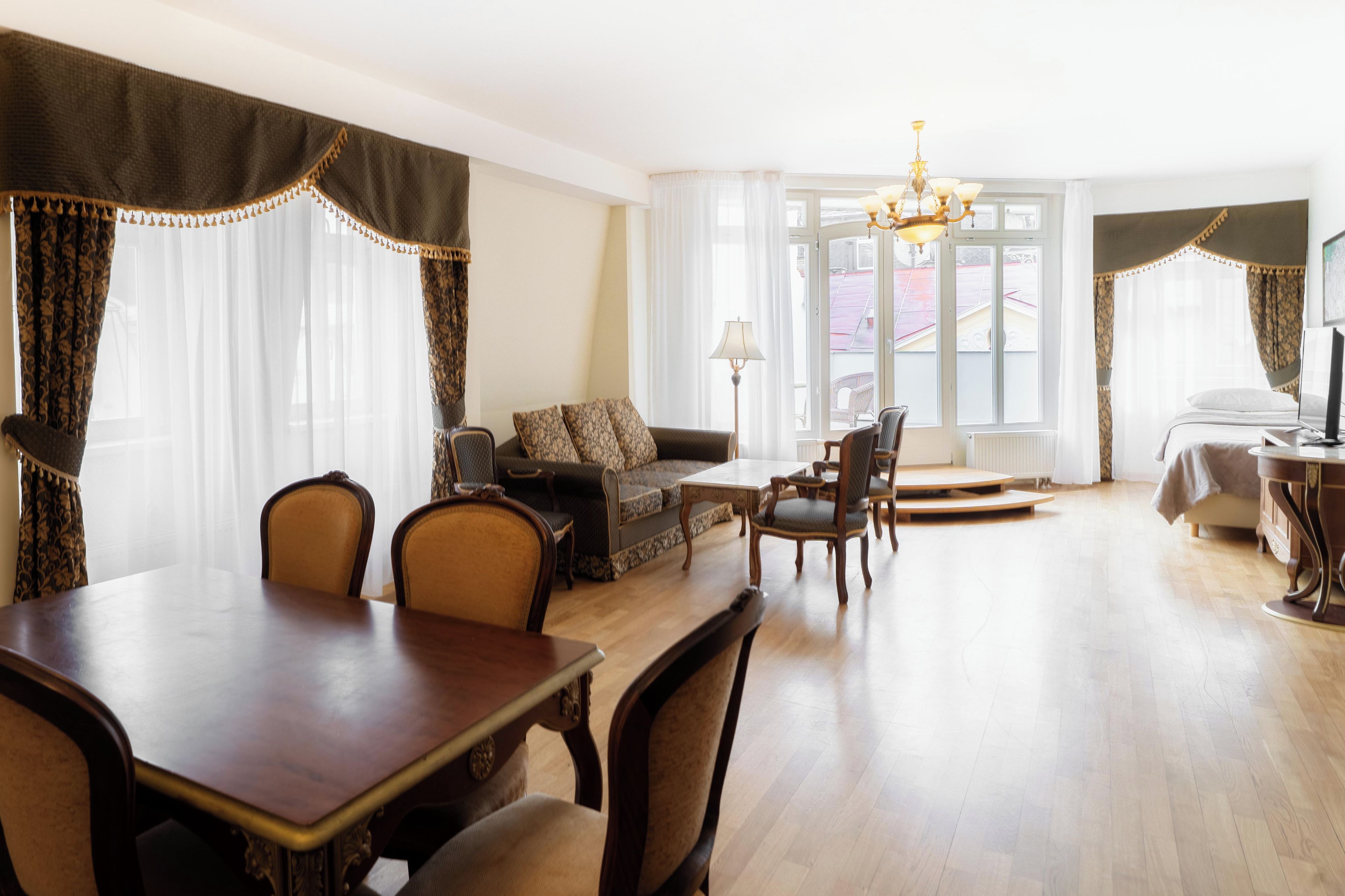 Een hotelkamer met een zithoek, een bank, een lamp en uitzicht.