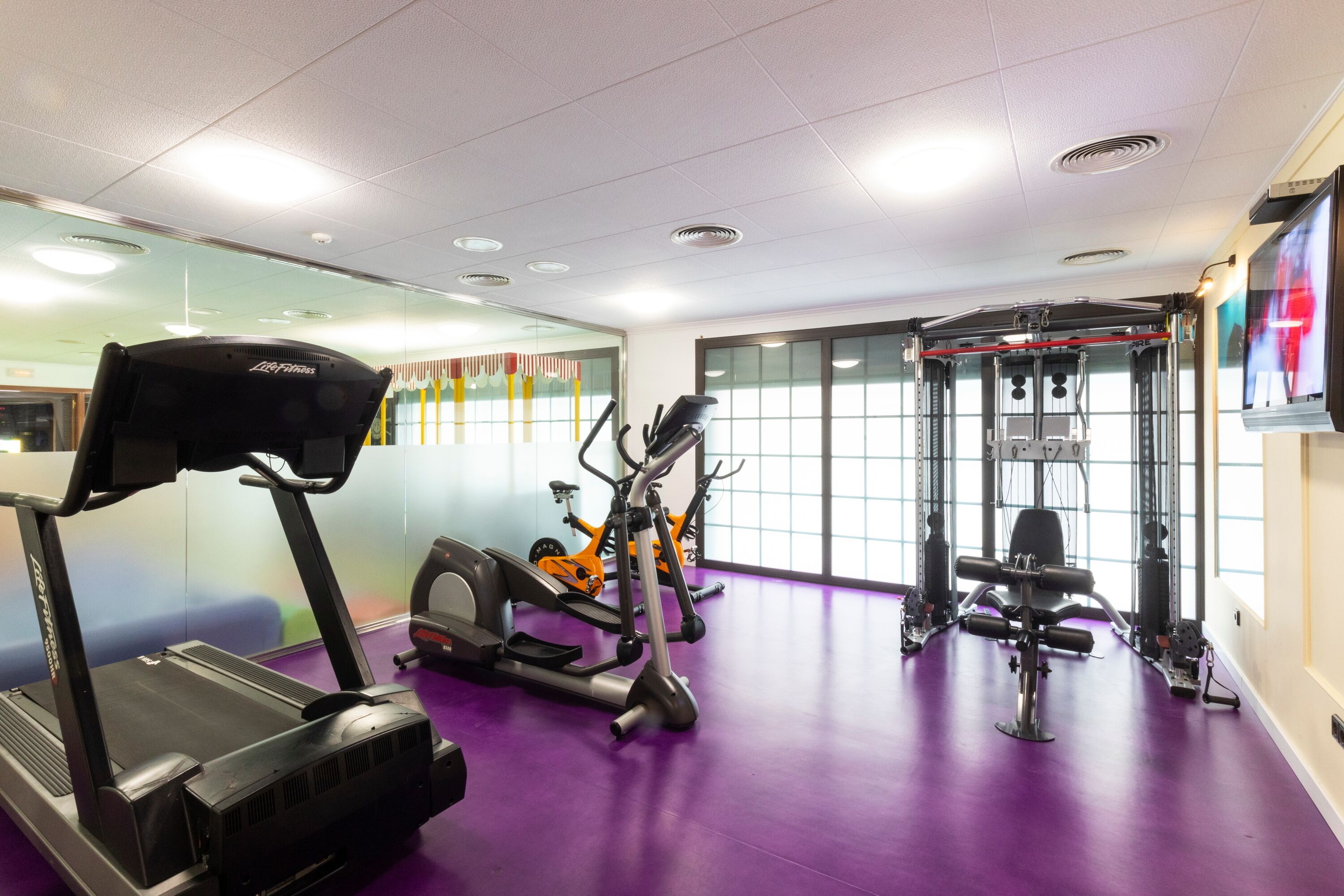 A gym with treadmills, an elliptical, and a weight machine.