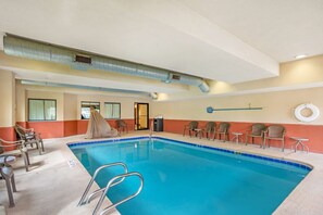 An indoor swimming pool with clear blue water, surrounded by lounge chairs and a covered area. - Best Western Danville Inn (Danville)