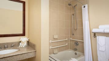 A bathroom with a sink, mirror, shower, and bathtub.