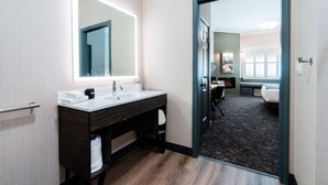 A modern bathroom with a double sink vanity, a large mirror, and a dark wood cabinet.