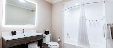 A modern bathroom with a vanity, toilet, and bathtub.