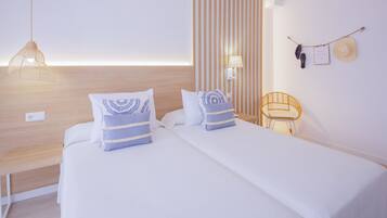 Habitación de hotel con dos camas, cabecero de madera, lámpara colgante, lámpara de pared, una silla de madera pequeña y un perchero de pared con un sombrero y un par de zapatos.