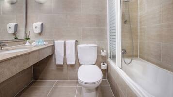 Un baño moderno con inodoro, lavamanos y ducha.