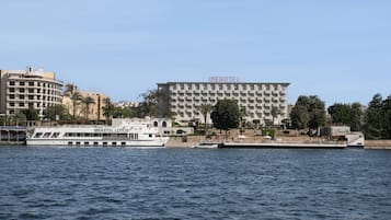 Un hotel frente al agua con un edificio grande identificado como 'IBEROTEL' y un barco amarrado al frente.